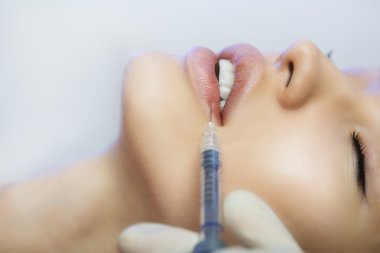 Woman Gets an Injection in her Lips in Beauty Salon clipart