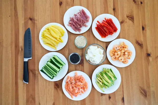 Suşi malzemeleri ahşap masaya yerleştirildi. Evde suşi yapmak için hazır.