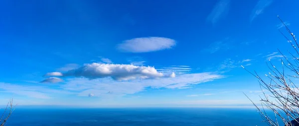 Sky and sea. Clouds of different shapes and the sea is divided by the horizon line