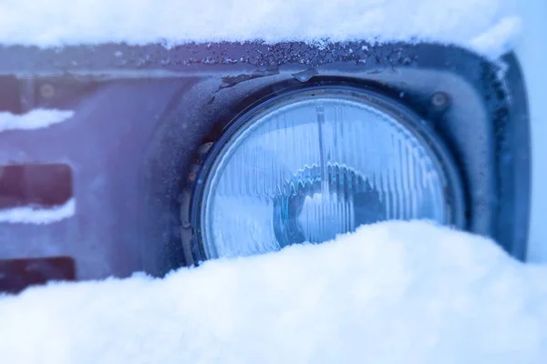 Arabanın farları kötü havada karla kaplıydı.)