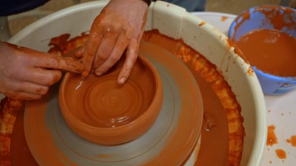 ポッターは ポッターホイール クローズアップ にクレイボウルを彫刻します 陶芸家の手は陶芸家の車輪の上に粘土のボウルを形成します — ストック動画