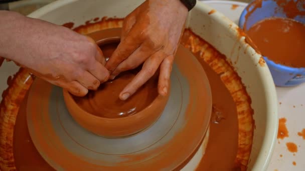 陶芸家の指が土鉢を形成します 陶芸品はろくろを回転させます クローズアップ — ストック動画