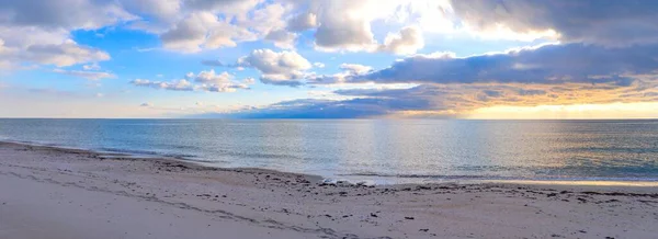 Akşamları Karadeniz kıyısındaki kumsal. Güneş ufuktan batıyor, deniz yüzeyinde ve bulutlarda altın yansımalar bırakıyor.