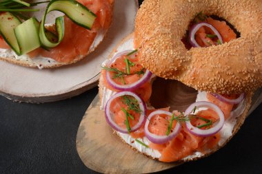 Somon, krem peynir, salatalık ve soğanlı simit sandviç.