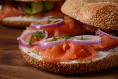 Somon, krem peynir, salatalık ve soğanlı simit sandviç.