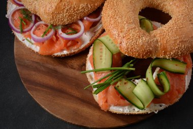 Somon, krem peynir, salatalık ve soğanlı simit sandviç.