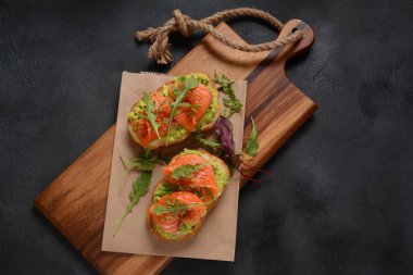 Avokado, somon ve roka yapraklı tam tahıllı ekmek..