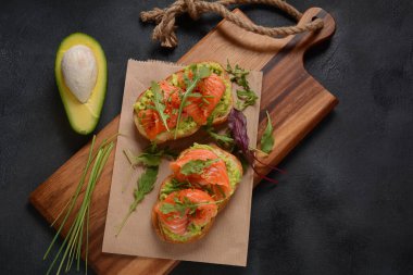 Avokado, somon ve roka yapraklı tam tahıllı ekmek..