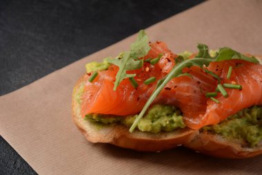 Avokado, somon ve roka yapraklı tam tahıllı ekmek..