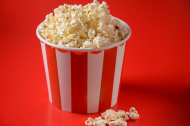 Kırmızı arka planda lezzetli patlamış mısır kovaları. Dökülmüş patlamış mısır 