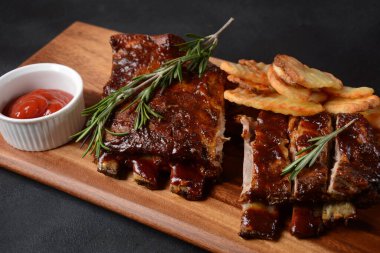 Barbekü soslu ızgara domuz pirzolası ve balda karamelize edilmiş. Tahta bir tahtanın üzerinde biraya lezzetli atıştırmalıklar. Baharatlı ızgara domuz kaburgası.