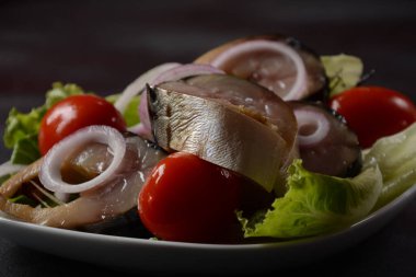 Vişneli domatesli soğuk füme uskumru balığı ve marul yapraklı kırmızı soğan dilimleri..