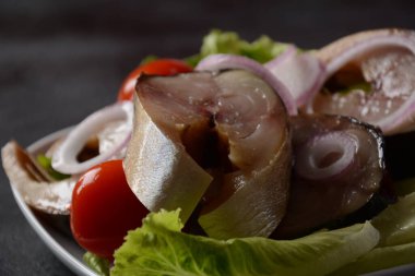 Vişneli domatesli soğuk füme uskumru balığı ve marul yapraklı kırmızı soğan dilimleri..