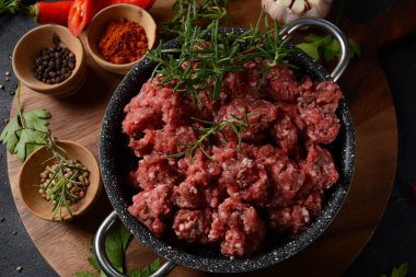 Kıymalı biftek. Siyah arka planda yemek pişirmek için içerikli öğütülmüş et.