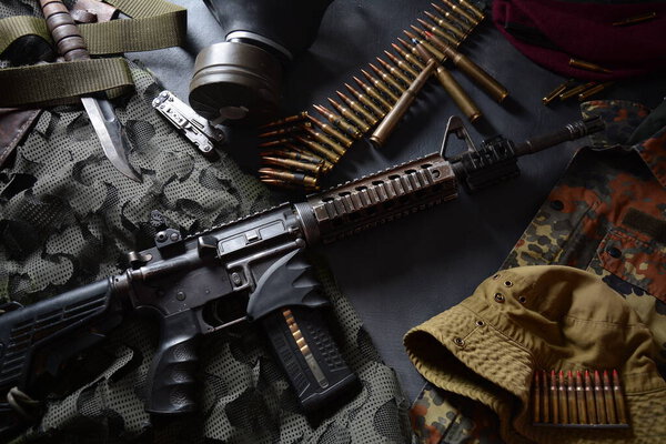 Штурмовая винтовка (М4А1) с боеприпасами на камуфляжной форме и военной техникой для армии, пуль и магазина