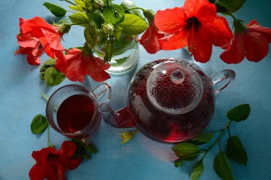 Şeffaf bir çaydanlıkta Hibiscus çayı ve çiçek.