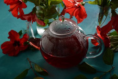 Şeffaf bir çaydanlıkta Hibiscus çayı ve çiçek.