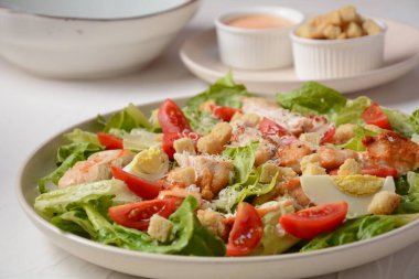 Kızarmış tavuklu Sezar Salatası, salatalı Peynir ve kızarmış ekmek, tabakta. Izgara tavuk göğsü ve taze sebzeler..