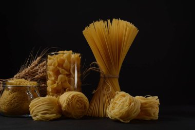 Çeşitli İtalyan makarnaları. Pişmemiş spagetti, tagliatelle. Makarna için İtalyan yemekleri.