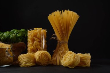 Çeşitli İtalyan makarnaları. Pişmemiş spagetti, tagliatelle. Makarna için İtalyan yemekleri.