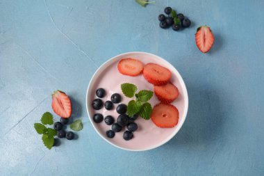 Bir kase taze böğürtlen, yoğurt, taze çilek ve yabanmersini.
