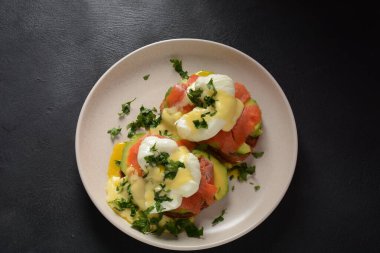 Tütsülenmiş somon, avokado dilimleri ve Hollandaise soslu yumurta.