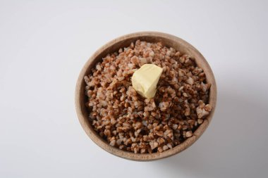 Bir kase lezzetli karabuğday lapası ve üstünde tereyağı var.