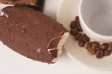 Çikolata ve kahve aromalı buzlu, beyaz fincan ve kahve çekirdekli.