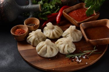 Geleneksel Gürcü mutfağı, kırmızı biberli Gürcü usulü Khinkali köftesi. Yerel soslu Khinkali - tkemali, satsebeli, adzhika.