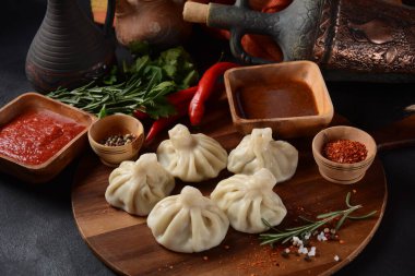 Geleneksel Gürcü mutfağı, kırmızı biberli Gürcü usulü Khinkali köftesi. Yerel soslu Khinkali - tkemali, satsebeli, adzhika.