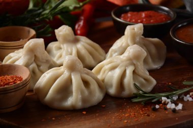 Geleneksel Gürcü mutfağı, kırmızı biberli Gürcü usulü Khinkali köftesi. Yerel soslu Khinkali - tkemali, satsebeli, adzhika.