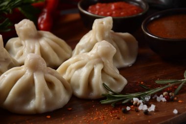 Geleneksel Gürcü mutfağı, kırmızı biberli Gürcü usulü Khinkali köftesi. Yerel soslu Khinkali - tkemali, satsebeli, adzhika.