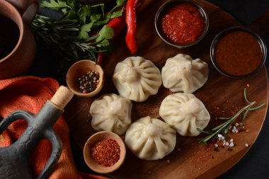 Geleneksel Gürcü mutfağı, kırmızı biberli Gürcü usulü Khinkali köftesi. Yerel soslu Khinkali - tkemali, satsebeli, adzhika.