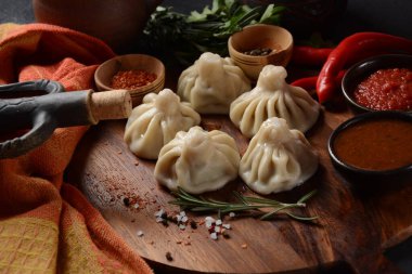 Geleneksel Gürcü mutfağı, kırmızı biberli Gürcü usulü Khinkali köftesi. Yerel soslu Khinkali - tkemali, satsebeli, adzhika.