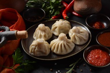 Geleneksel Gürcü mutfağı, kırmızı biberli Gürcü usulü Khinkali köftesi. Yerel soslu Khinkali - tkemali, satsebeli, adzhika.