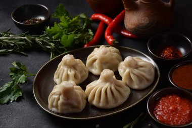 Geleneksel Gürcü mutfağı, kırmızı biberli Gürcü usulü Khinkali köftesi. Yerel soslu Khinkali - tkemali, satsebeli, adzhika.