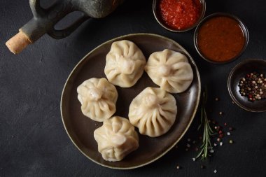 Geleneksel Gürcü mutfağı, kırmızı biberli Gürcü usulü Khinkali köftesi. Yerel soslu Khinkali - tkemali, satsebeli, adzhika.