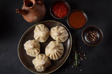 Geleneksel Gürcü mutfağı, kırmızı biberli Gürcü usulü Khinkali köftesi. Yerel soslu Khinkali - tkemali, satsebeli, adzhika.