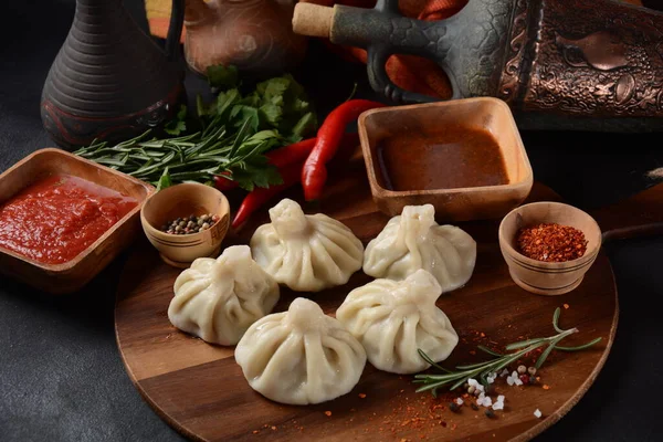 Geleneksel Gürcü mutfağı, kırmızı biberli Gürcü usulü Khinkali köftesi. Yerel soslu Khinkali - tkemali, satsebeli, adzhika.