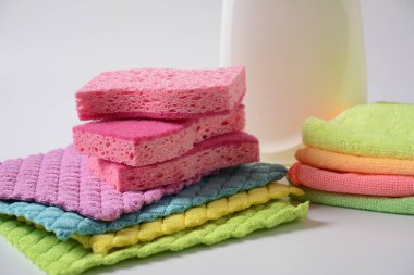 Pembe temizlik süngerleri ve çok renkli mikro fiber temizlik bezleri.