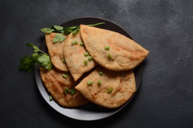 Chebureki, etli ve soğanlı kızarmış turta. Kafkas mutfağı, içi doldurulmuş kuzu eti ve baharatlı baharatla mayalanmamış hamur köftesidir..