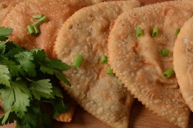Chebureki, etli ve soğanlı kızarmış turta. Kafkas mutfağı, içi doldurulmuş kuzu eti ve baharatlı baharatla mayalanmamış hamur köftesidir..