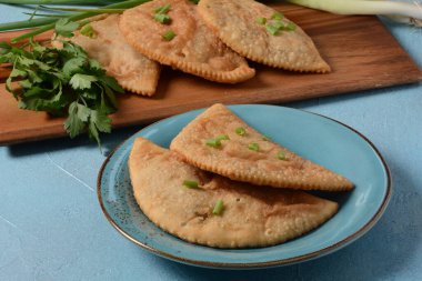 Chebureki, etli ve soğanlı kızarmış turta. Kafkas mutfağı, içi doldurulmuş kuzu eti ve baharatlı baharatla mayalanmamış hamur köftesidir..
