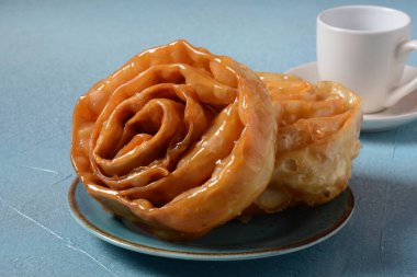 Ramazan için taze pişmiş chebakia. Chebakia Fas hamur işleri. Hamur şeritlerinden yapılmış, gülü andırmak için sarılmış, altın olana kadar kızartılmış, sonra da bal ve gül suyundan yapılmış bir şurupla kaplanmış..