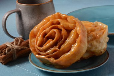 Ramazan için taze pişmiş chebakia. Chebakia Fas hamur işleri. Hamur şeritlerinden yapılmış, gülü andırmak için sarılmış, altın olana kadar kızartılmış, sonra da bal ve gül suyundan yapılmış bir şurupla kaplanmış..