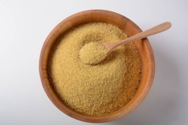 Beyaz masa arkasında ahşap kasede pişmemiş bulgur, köy usulü. Bulgur buğdayları