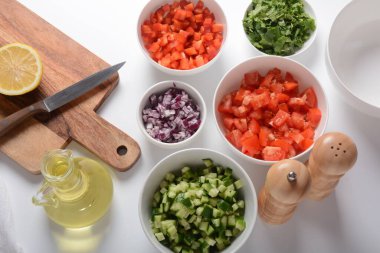 Farklı renklerde rendelenmiş sebzelerle dolu beyaz kaseler. İçindekilerle birlikte salata için yemek tahtası..