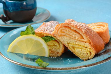 Limonlu ve naneli Avusturya turtası ve tabakta pudra şekeri. Portakal ve limon reçelli kek.