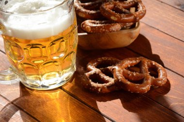 Sert krakerler ya da tuzlu krakerler kırsal ahşap masada bir bardak birayla parti için atıştırmalık.