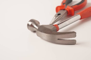 Beyaz arka planda çekiç ve pense var. Standart pençe çekici ve İğne Burun Pensesi görüntüsünü kapat